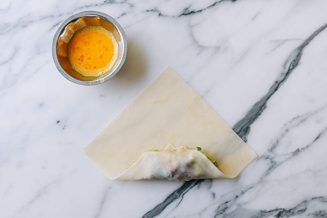 Rolling corner of egg roll wrapper over filling, aedison.aieoederdu.tk
